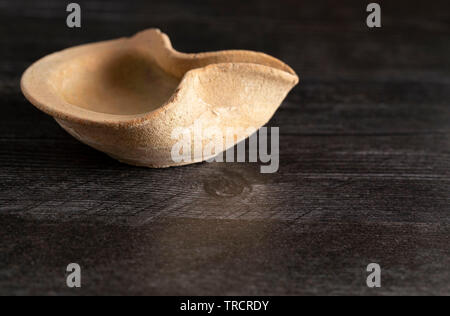 Lampe à huile à la main du Moyen-Orient sur une table en bois sombre. Banque D'Images