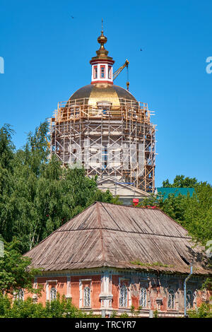 Processus de reconstruction de la cathédrale orthodoxe russe dans le village local à l'aide d'échafaudages et de grues. Banque D'Images