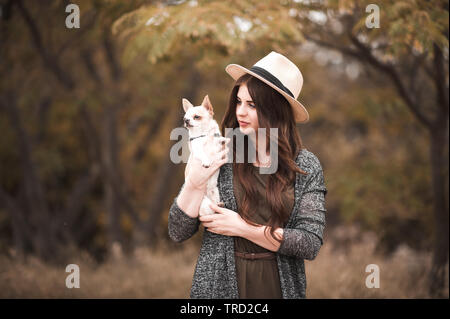 De 20 à 24 ans fille élégante holding chihuahua animaux à l'extérieur. La solidarité. Banque D'Images