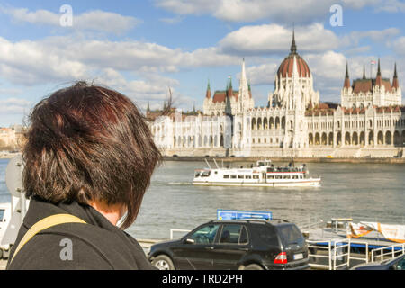 BUDAPEST, HONGRIE - Mars 2018 : visiteuse en Hongrie sur le Danube et le bâtiment du parlement hongrois Banque D'Images