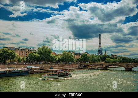 La Tour Eiffel, le pont et le bateau naviguant sur le fleuve Seine, journée ensoleillée à Paris. L'un des plus impressionnants du monde centre culturel en France. Banque D'Images