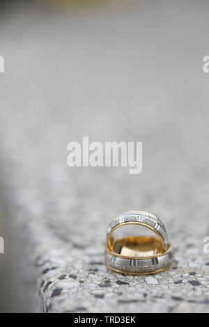 Anneaux de mariage d'or sur une surface en pierre. Banque D'Images