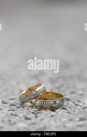 Anneaux de mariage d'or sur une surface en pierre. Banque D'Images