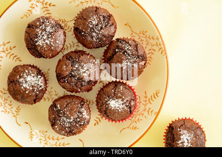 Fresh baked mini brownies au chocolat saupoudrée de sucre glace sur la jolie plaque ronde en composition horizontale. Banque D'Images
