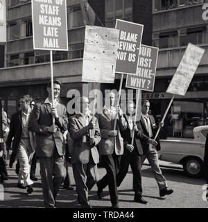 1960s, historique, frappant Royal Mail des travailleurs postaux marchant dans le centre de Londres holding des placards, un disant...'notre première grève Pourquoi? Les postiers de la succursale de Kilburn protestaient contre leurs bas salaires et demandaient un accord sur l'échec des salaires, avec une colère particulière avec Ernest Bevin, le co-fondateur, En janvier 1922 - et ancien Secrétaire général - du Syndicat des transports et des travailleurs généraux (TGWU) qui était devenu le plus grand syndicat de Grande-Bretagne. Banque D'Images