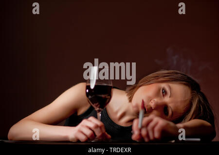 Portrait d'une femme ivre avec un verre de vin et une cigarette dans ses mains Banque D'Images