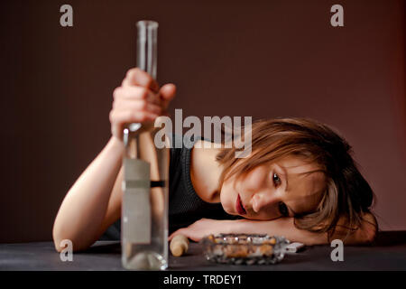 Portrait d'une femme ivre avec une bouteille de vin dans sa main Banque D'Images