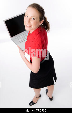 Portrait d'une jeune femme sympathique business woman holding a laptop dans l'appareil photo Banque D'Images