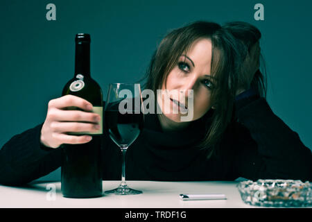 Portrait d'un déprimé et femme désalcoolisée tenant une bouteille de vin Banque D'Images