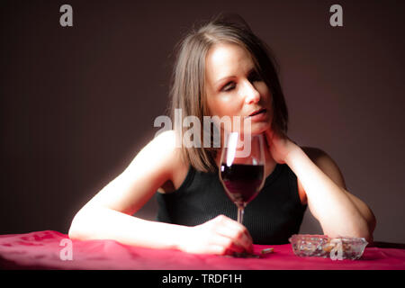 Portrait d'un déprimé et femme désalcoolisée tenant un verre de vin rouge Banque D'Images