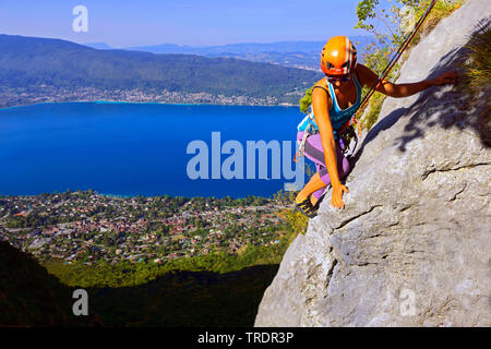 Grimpeur féminin sur un rocher sur le lac d'Annecy, France, Savoie Banque D'Images