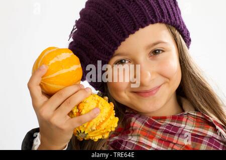 Portrait d'une jeune fille aimable jaune tenant dans sa main les gourdes de décoration Banque D'Images