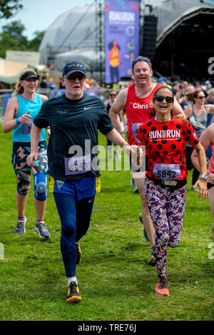 Présentateur de télévision, radio DJ et homme Chris Evans et sa femme Natasha tenir la main qu'ils prennent part à une course de 5km à courir Fest. Banque D'Images