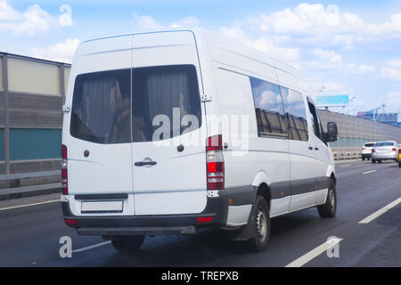 Minibus blanc va sur la ville street Banque D'Images