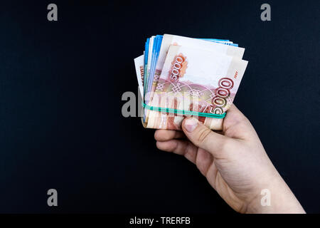 Man hands holding pile d'argent. l'argent enveloppé dans des bandes de caoutchouc dans les mains de l'homme Banque D'Images