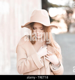 Girl wearing élégant manteau d'hiver beige et un chapeau à l'extérieur. À la mode. 20s. Banque D'Images