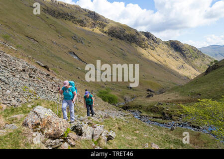 Deux marcheurs faire leur chemin jusqu'à Dovedale Crag colombe avec la crête d'Hartsop Comment ci-dessus de l'horizon, Lake District, Cumbria, Royaume-Uni Banque D'Images