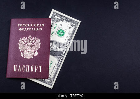 Un passeport russe et un dollars américains sur fond noir. Passeport dans la couvercle rouge et l'argent américain. La notion de voyage, de la richesse, independenc Banque D'Images