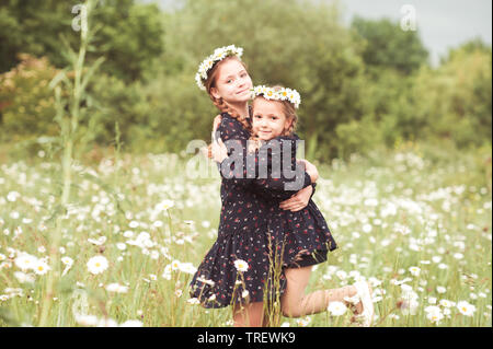 Deux sœurs heureux s'amusant à l'extérieur de la zone. En regardant la caméra. L'enfance. Banque D'Images