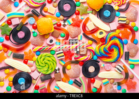 Assortiment de sucettes, bonbon de fruits et bonbons sur fond rose comme Banque D'Images