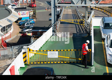 Équipier ferme la porte d'accès à la location de pont d'un traversier voyageant entre Red Funnel East Cowes sur l'île de Wight et Southampton / continent. UK. (99) Banque D'Images