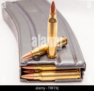 Un fusil de calibre 223 metal magazine chargé avec des balles de calibre 223 avec deux balles dessus isolé sur fond blanc Banque D'Images