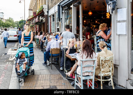 Diners en plein air à l'extérieur de la Farola et autres restaurants sur Theberton Street, off Upper Street, London, UK Banque D'Images