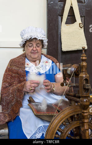 Femme en costume traditionnel démontrant l'art de la filature, à l'aide de poils de chat, à une foire artisanale, Lamport Hall, le Northamptonshire, Angleterre Banque D'Images