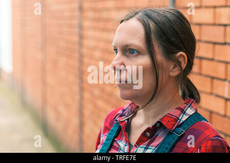 La productrice de pensée. Portrait d'une femme de race blanche adultes debout devant la ferme. Banque D'Images