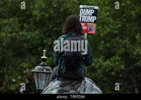 Londres, Royaume-Uni. 4 juin 2019. Un seul manifestant se trouve à la tête de l'une des statues du lion noir de Trafalgar Square, le jour où des manifestants ont tenu une manifestation de masse dans le centre de Londres sur Trafalgar Square contre le président des États-Unis, Donald Trump, en visite au Royaume-Uni. Crédit: Joe Kuis / Alay Banque D'Images