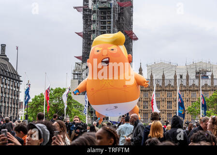 Donald Trump bébé ballon dirigeable à Parliament Square, Londres, Royaume-Uni au cours nous Président Visite d'État. Volant au-dessus des personnes en face du Parlement, UK Banque D'Images