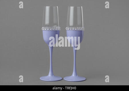 Deux verres à vin de mariage en couleur lavande sur fond gris. Banque D'Images