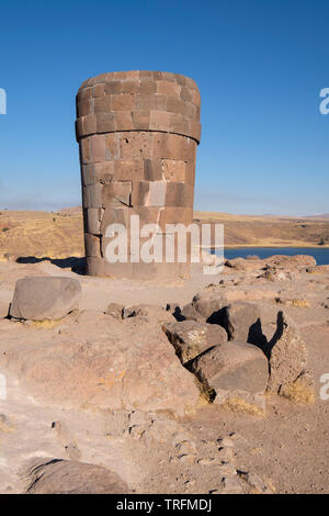 Inhumation pré-Inca impressionnante tour appelée chullpa avec le lac Umayo en arrière plan à Sillustani, région de Puno, Pérou Banque D'Images