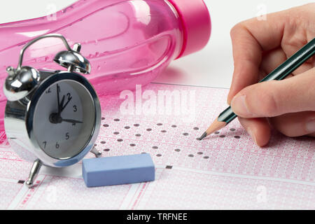 Les élèves de l'école mains participer aux examens, l'examen écrit au crayon optique sur la forme de test normalisé avec feuille de réponses faisant examen final en cla Banque D'Images