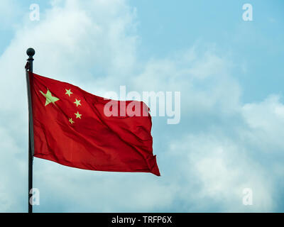 Drapeau national de la République populaire de Chine Personnes volant à mât complet contre le ciel bleu Banque D'Images