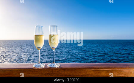 Deux verres de champagne à balustrade de bois du navire de croisière. Arrière-plan de la mer. Lune de miel romantique concept. Banque D'Images