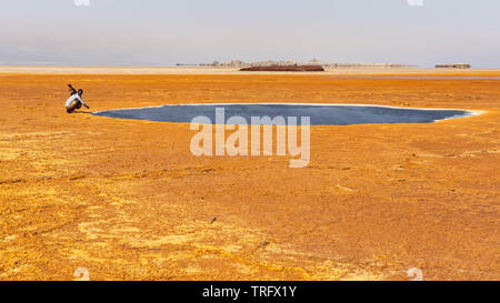 Soldat à l'Afar à la piscine noire dans la dépression Danakil Dallol, en Afrique. Banque D'Images