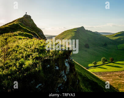Walker sur le sommet de la colline de Parkhouse face aux Chrome Hill et le Dragon est de retour dans la région de Dovedale dans le parc national de Peak District UK Banque D'Images