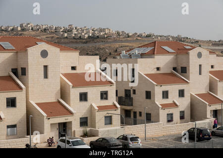 Jérusalem, Israël. 5 juin, 2019. Une vue vers le nord de Jérusalem, Pisgat Zeev illustre quartier récemment construits de maisons au toit rouge en premier plan avec la barrière de sécurité d'Israël au milieu de terrain et la périphérie de Qalandiya palestinienne et au-delà de Jaba. Ministère du logement d'Israël a récemment publié des appels d'offres pour la construction de 805 nouveaux logements dans le quartier de Ramot et Pisgat Zeev condamnation de l'UE de dessin (01 juin 2019) et a déclaré "l'Union européenne est fermement opposé à la politique de colonisation d'Israël, y compris à Jérusalem-Est, ce qui est illégal en vertu du droit international et un Banque D'Images