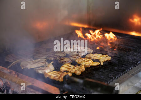 Un assortiment de grillades brochettes de viande de poulet, d'agneau et de porc mariné kofte, saucisses et légumes divers griller sur la grille du barbecue cuit Banque D'Images