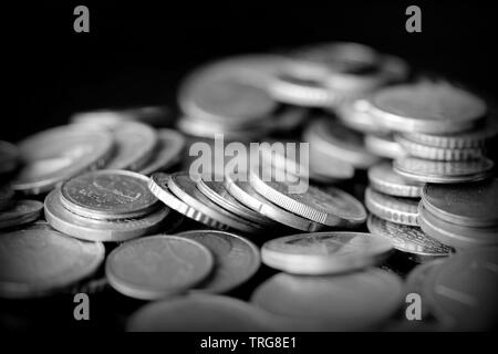 Pièces en Euro éparpillés sur une surface sombre, Close up. Le noir et blanc Banque D'Images