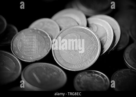 Pièces en Euro éparpillés sur une surface sombre, Close up. Le noir et blanc Banque D'Images