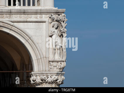 La statue d'Adam à l'angle du palais des Doges à Venise contre un bleu, ciel d'été. Banque D'Images