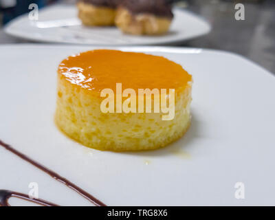 Flan au caramel sur une assiette blanche Banque D'Images