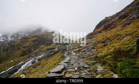 Paysage magnifique avec un ciel brumeux, la fonte des glaces et de la route entre les belles montagnes escarpées - capturés au cours d'une randonnée à Snowdon en hiver (Na Snowdonia Banque D'Images