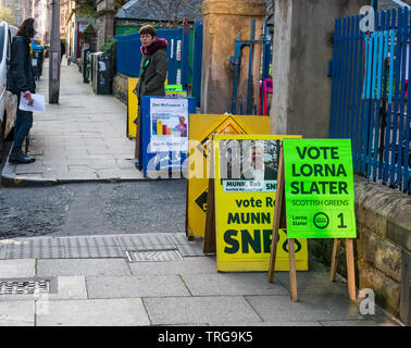 Homme marchant passé Lorne l'école primaire de scrutin à l'élection partielle du Conseil de Leith Walk, Edinburgh, Scotland, UK avec les conseils politiques de parti Banque D'Images