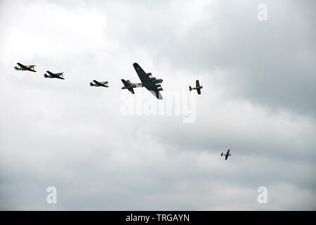 P-51 Mustang USAF avec D-day invasion stripes voler en formation avec B17 Flying Fortress à Duxford Banque D'Images