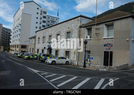 Poste de police et voiture à Gibraltar garé drapeau à l'extérieur des marquages routiers marqués de grands bâtiments chemin routier lampadaire de style ancien flics britanniques Banque D'Images