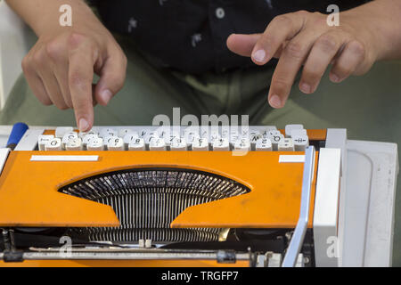 Jeune homme travaillant sur la vieille machine à écrire manuelle vintage Banque D'Images