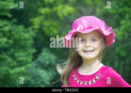 Portrait en extérieur d'une petite fille portant un chapeau d'été. Copie espace vers la gauche. Banque D'Images